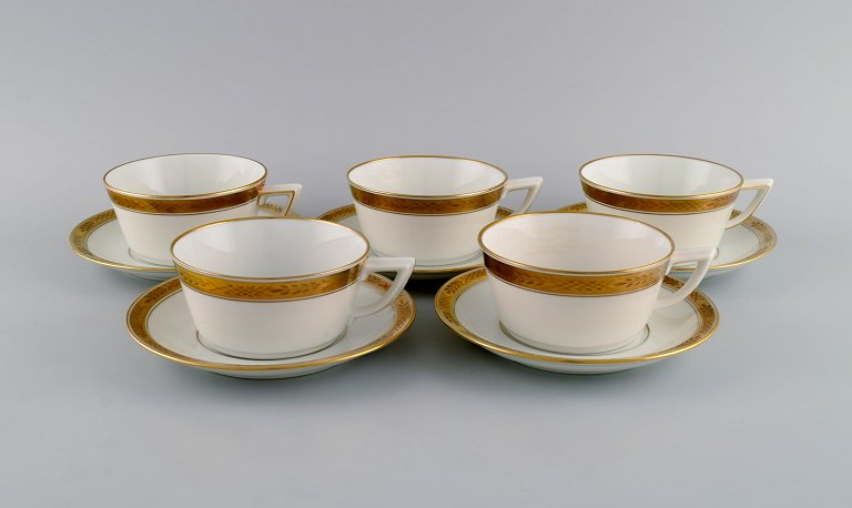 Royal Copenhagen service no. 607. Five teacups with saucers. Gold border with 
foliage. 1960s. Model number 607/9536.
