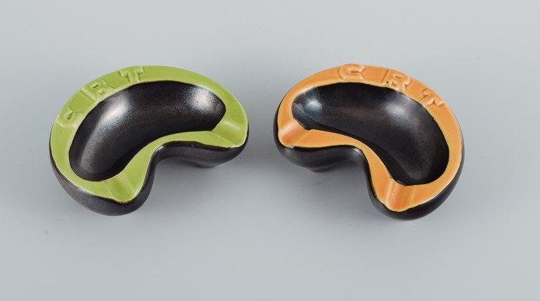 Vallauris, France, two ceramic bowls with yellow and green glazes on a black 
base.