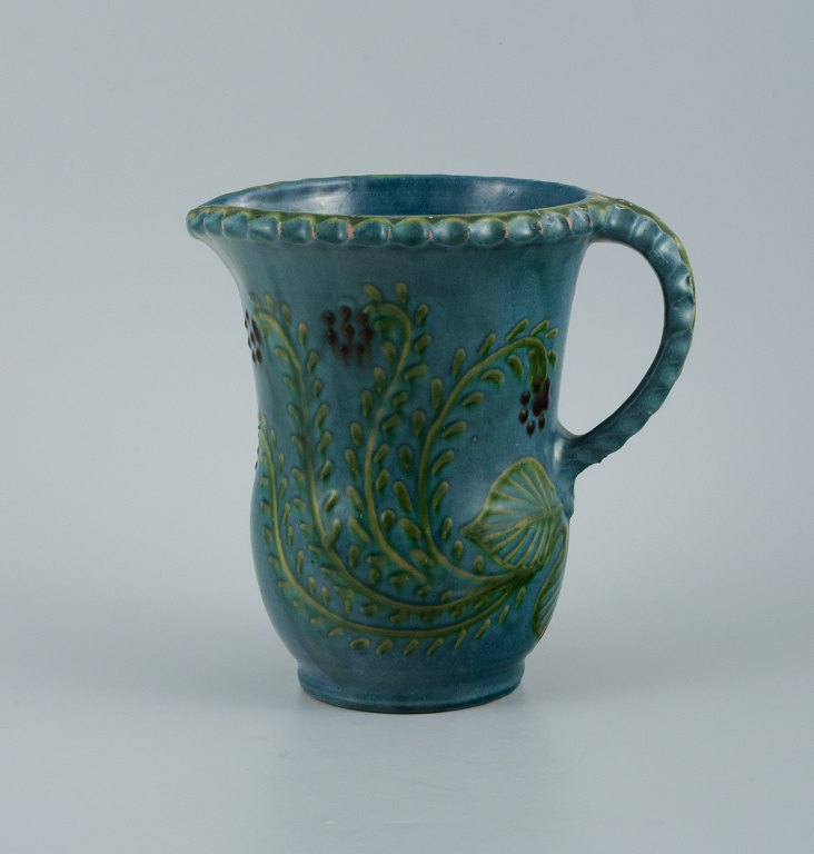 Kähler kande i glaseret keramik. Dekoreret med blomster på blå baggrund.
