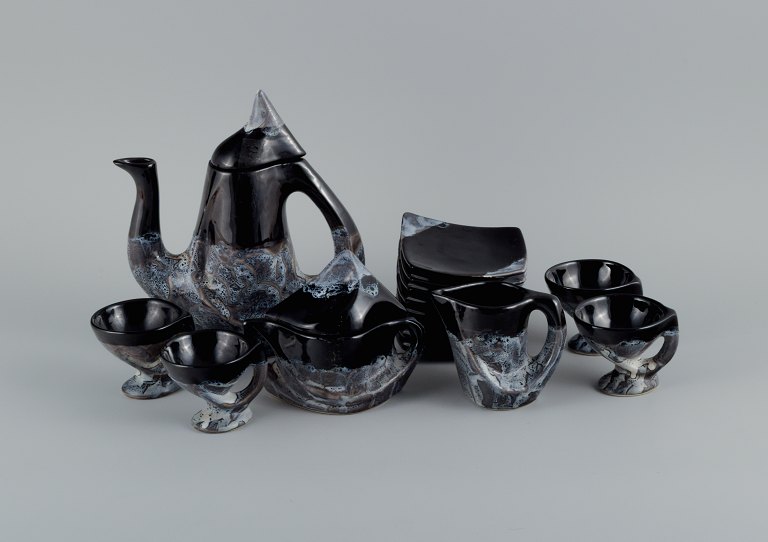 Vallauris, France.
A modernistic four-person coffee service in ceramics consisting of four coffee 
cups with matching saucers, coffee pot, creamer, sugar bowl and three small 
plates.
