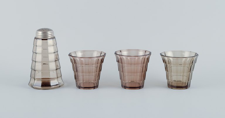 Simon Gate (1883-1945) for Orrefors/Sandvik, Sweden.
A set of three drinking glasses and a sugar shaker in Art Deco style, in smoked 
coloured pressed glass.