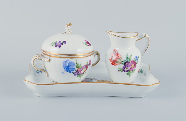 Royal Copenhagen, Saxon Flower, a sugar bowl and creamer on tray, hand-decorated 
with polychrome flowers and gold rim.