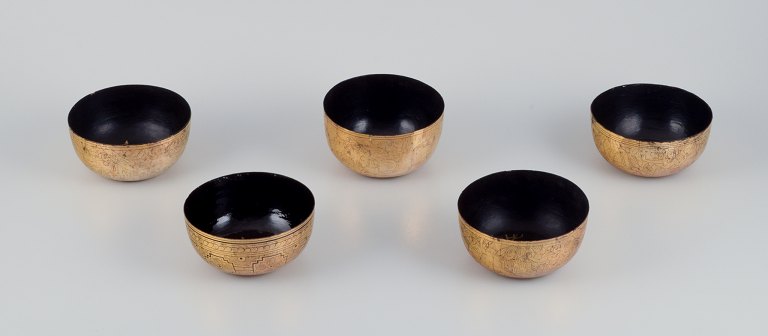 Five Asian bowls made of papier-mâché. Decorated in gold and black with 
traditional motifs.