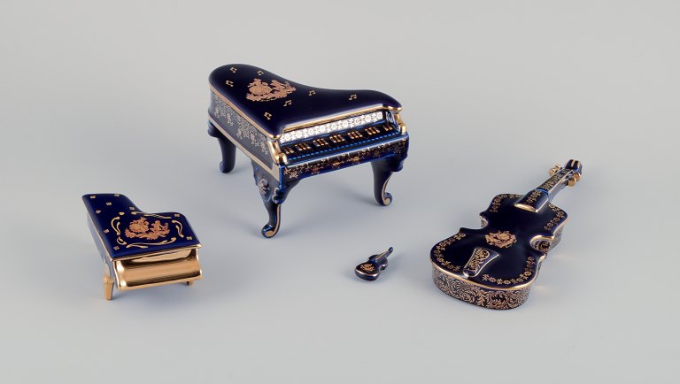 Limoges, France. Four porcelain musical instruments decorated with 22-karat gold 
leaf and beautiful royal blue glaze. Scène galante.