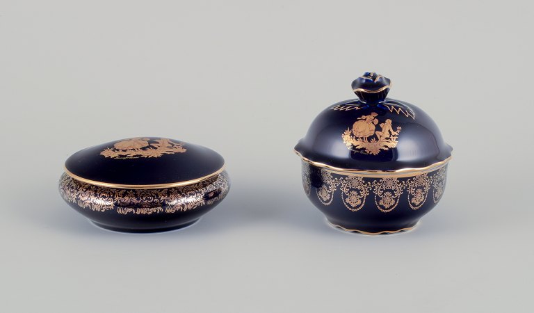 Limoges, France. Two porcelain lidded jars in porcelain, decorated with 22-karat 
gold leaf and beautiful royal blue glaze. Scène galante.