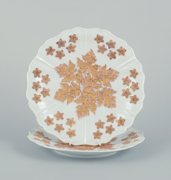 Meissen, Germany. A pair of antique porcelain plates decorated with flowers in 
gold leaf.