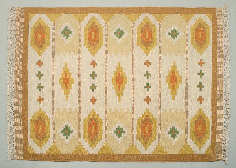 Swedish handwoven carpet in pure wool. Rölakan technique. Ochre yellow, orange, 
green, and white colors in a geometric pattern.