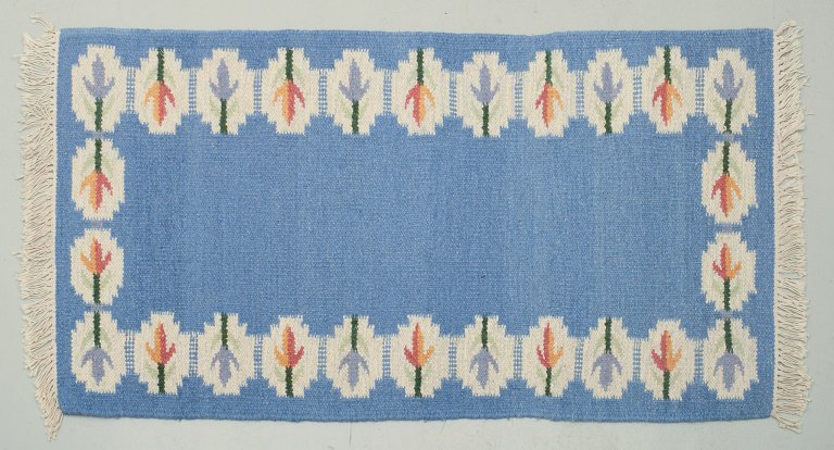 Swedish handwoven carpet in pure wool. Rölakan technique.
Designed with flowers on a blue background.