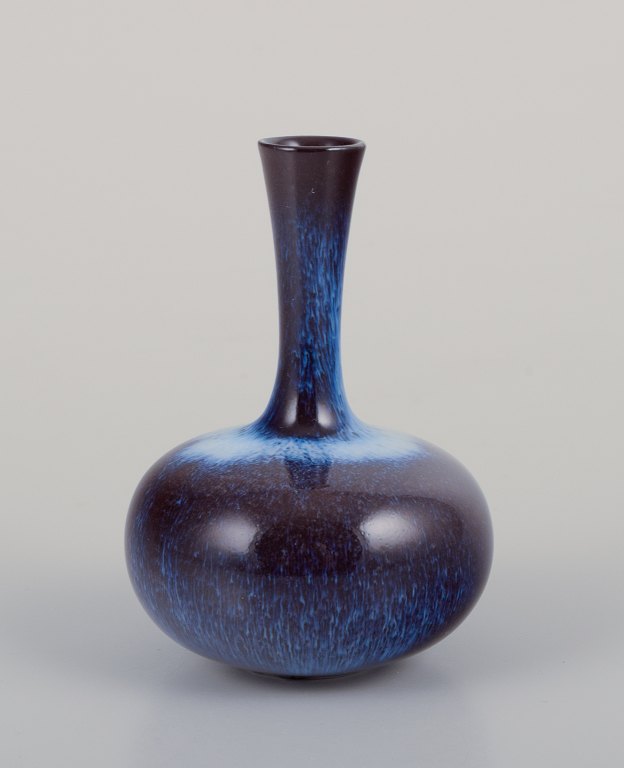 Gunnar Nylund (1904-1997) for Rörstrand, Sweden.
Miniature vase with a slender neck. Glaze in blue and violet tones.