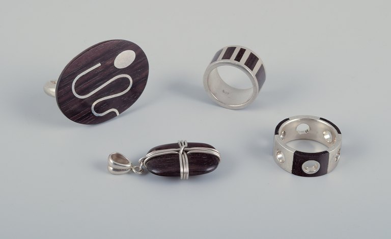 Swedish jewelry artist. Three rings and a pendant in sterling silver and dark 
wood.