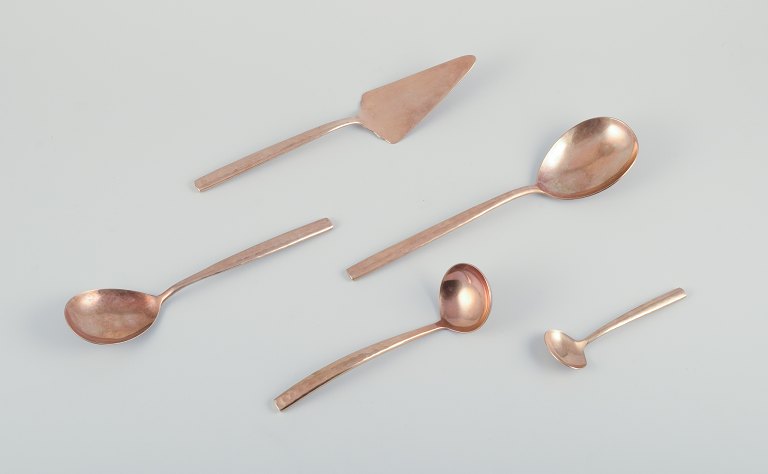 Scandinavian designer. Five serving pieces consisting of a gravy spoon, two 
large serving spoons, a jam spoon, and a butter knife in handcrafted hammered 
brass. High-quality craftsmanship.