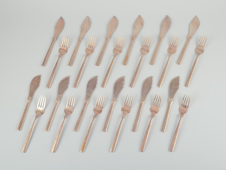 Scandinavian designer. Complete twelve-person fish service consisting of twelve 
fish knives and twelve fish forks in handcrafted hammered brass. High-quality 
craftsmanship.