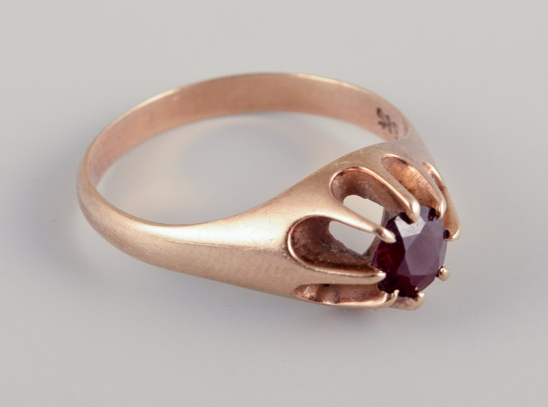 Danish goldsmith. 14 karat Art Deco gold ring adorned with Burgundy-colored 
semi-precious stone.