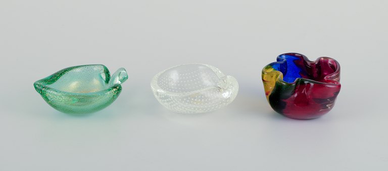 Three Murano art glass bowls.
Polychrome glass, clear glass with bubbles, and green glass with gold dust.